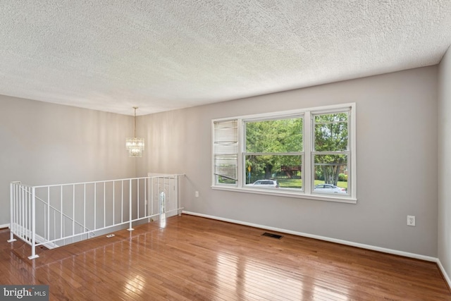 9405 Loughran Rd, Fort Washington, MD 20744 - unfurnished room with a chandelier, wood-type flooring, and a textured ceiling