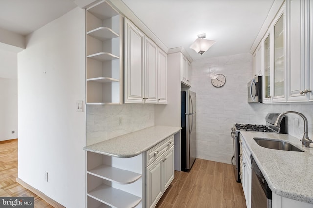 2475 Virginia Ave NW Unit 600, Washington, DC 20037 - kitchen with open shelves, stainless steel appliances, white cabinetry, light stone counters, and light wood-type flooring