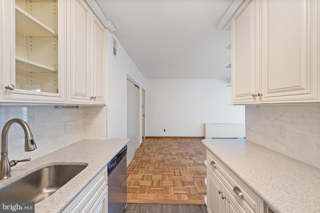 2475 Virginia Ave NW Unit 600, Washington, DC 20037 - kitchen with dishwasher, decorative backsplash, light stone counters, glass insert cabinets, and open shelves