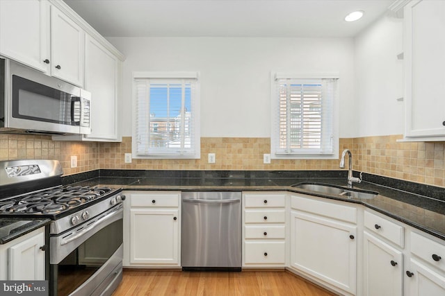 19 Yogurt Ln, Baltimore, MD 21231 - kitchen with stainless steel appliances, white cabinetry, dark stone counters, backsplash, and light wood-type flooring