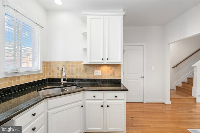 19 Yogurt Ln, Baltimore, MD 21231 - kitchen featuring open shelves, white cabinets, light wood-type flooring, decorative backsplash, and dark stone counters