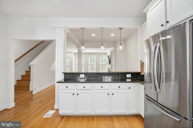 19 Yogurt Ln, Baltimore, MD 21231 - kitchen featuring freestanding refrigerator, a peninsula, white cabinets, decorative backsplash, and light wood-style flooring
