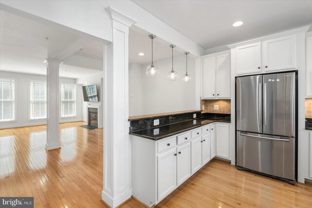 19 Yogurt Ln, Baltimore, MD 21231 - kitchen featuring freestanding refrigerator, decorative columns, white cabinetry, tasteful backsplash, and light wood finished floors