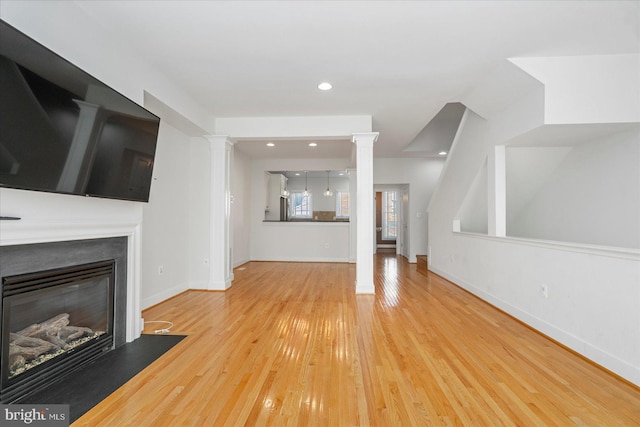 19 Yogurt Ln, Baltimore, MD 21231 - unfurnished living room featuring decorative columns, wood finished floors, a glass covered fireplace, and recessed lighting