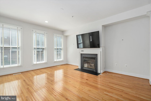 19 Yogurt Ln, Baltimore, MD 21231 - unfurnished living room with light wood-style flooring, a fireplace with flush hearth, healthy amount of natural light, and recessed lighting