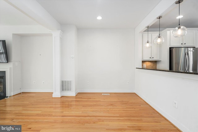19 Yogurt Ln, Baltimore, MD 21231 - unfurnished living room with light wood-type flooring, recessed lighting, a fireplace with flush hearth, and ornate columns