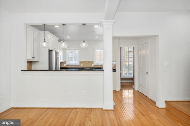 19 Yogurt Ln, Baltimore, MD 21231 - kitchen with freestanding refrigerator, ornate columns, dark countertops, light wood finished floors, and recessed lighting