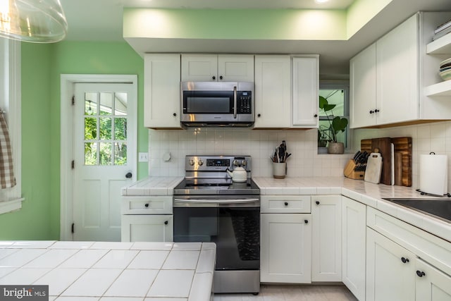 239 W Barnard St, West Chester, PA 19382 - kitchen with stainless steel appliances, open shelves, tile countertops, white cabinets, and backsplash