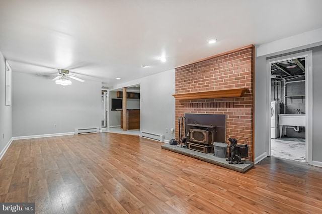 10 Sonora Dr, Pasadena, MD 21122 - unfurnished living room with a baseboard radiator, a ceiling fan, wood-type flooring, a wood stove, and recessed lighting