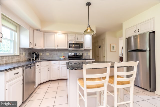 14 Winslow Way, Dresher, PA 19025 - kitchen featuring stainless steel appliances, light tile patterned floors, white cabinets, tasteful backsplash, and a kitchen island