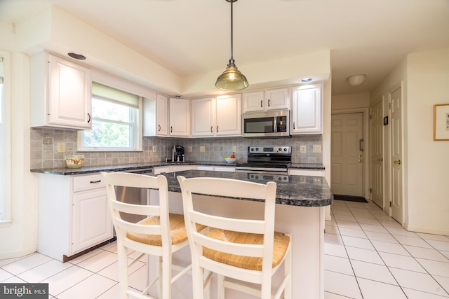 14 Winslow Way, Dresher, PA 19025 - kitchen featuring appliances with stainless steel finishes, light tile patterned floors, decorative backsplash, and white cabinets