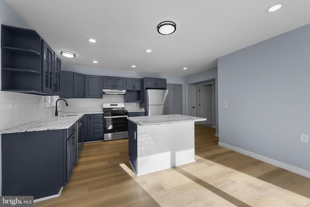 321 Curacao St, Toms River, NJ 08757 - kitchen with stainless steel gas range, freestanding refrigerator, under cabinet range hood, a kitchen island, and backsplash