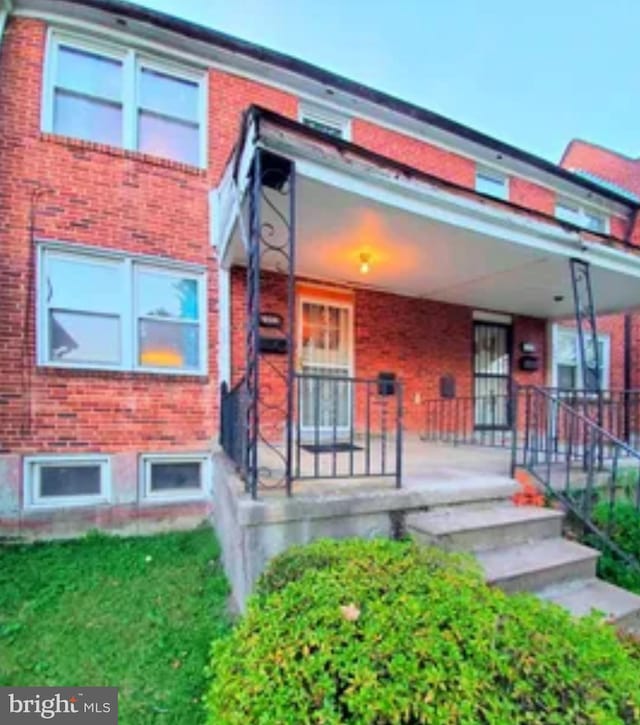 2204 N Dukeland St N, Baltimore, MD 21216 - view of front facade featuring brick siding and a porch