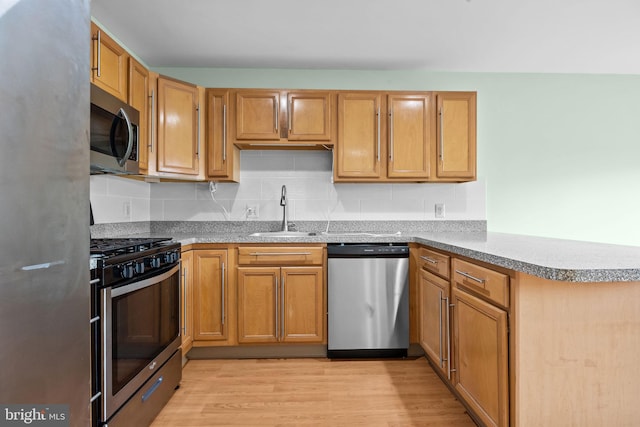 723 Dell Ct, Southampton, PA 18966 - kitchen with stainless steel appliances, a peninsula, decorative backsplash, and light wood-style floors