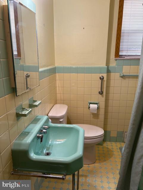 2642 S 17th St, Philadelphia, PA 19145 - bathroom featuring tile walls, wainscoting, and tile patterned floors