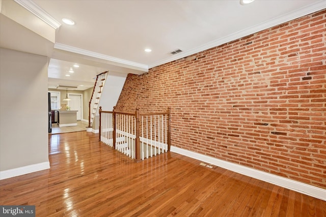 115 N Bradford St, Baltimore, MD 21224 - unfurnished room with wood-type flooring, crown molding, brick wall, and recessed lighting