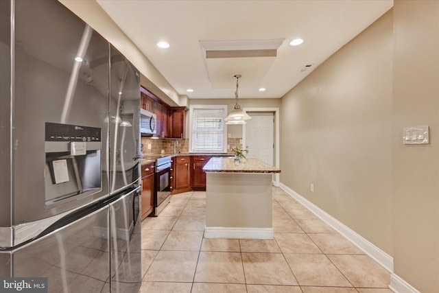 115 N Bradford St, Baltimore, MD 21224 - kitchen featuring appliances with stainless steel finishes, light stone countertops, decorative backsplash, light tile patterned floors, and hanging light fixtures