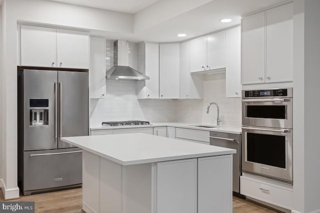 635 Slaters Ln Unit 109, Alexandria, VA 22314 - kitchen with stainless steel appliances, wall chimney range hood, light countertops, tasteful backsplash, and white cabinetry