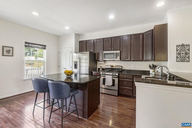 2159 Whispering Hollow Ln, Charlottesville, VA 22911 - kitchen with stainless steel appliances, a breakfast bar area, dark brown cabinets, dark wood finished floors, and recessed lighting