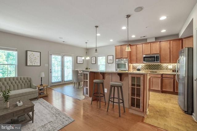 458 Exchange Ave Unit 458, Gaithersburg, MD 20878 - kitchen featuring stainless steel appliances, recessed lighting, tasteful backsplash, a breakfast bar area, and light stone counters