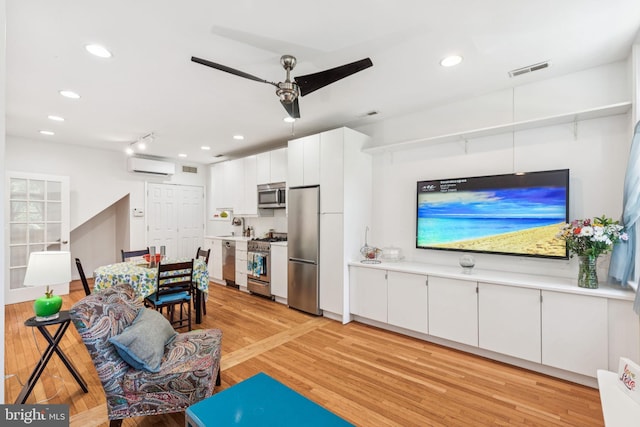 932 Locust St, Philadelphia, PA 19107 - living room with a ceiling fan, light wood-type flooring, a wall unit AC, and recessed lighting