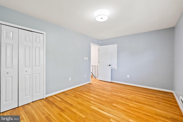 8700 Bluedale St, Alexandria, VA 22308 - unfurnished bedroom with light wood-style floors, a closet, and a baseboard heating unit