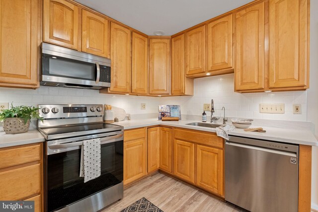 8700 Bluedale St, Alexandria, VA 22308 - kitchen with appliances with stainless steel finishes, backsplash, light wood-style floors, and light countertops