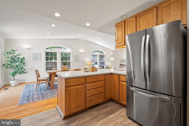 8700 Bluedale St, Alexandria, VA 22308 - kitchen with freestanding refrigerator, a peninsula, light countertops, light wood-type flooring, and vaulted ceiling