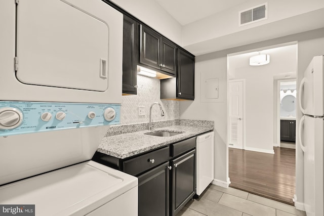 6930 Hanover Pkwy Unit 302, Greenbelt, MD 20770 - washroom featuring stacked washer and clothes dryer and light tile patterned floors