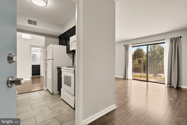 6930 Hanover Pkwy Unit 302, Greenbelt, MD 20770 - kitchen featuring white appliances, dark cabinets, and light wood finished floors