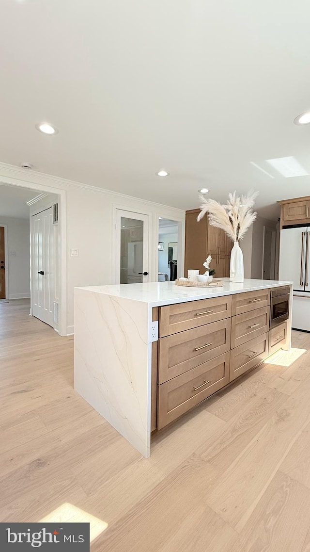 904 Man O War Ln, Great Falls, VA 22066 - kitchen with light wood-type flooring, freestanding refrigerator, stainless steel microwave, recessed lighting, and a kitchen island