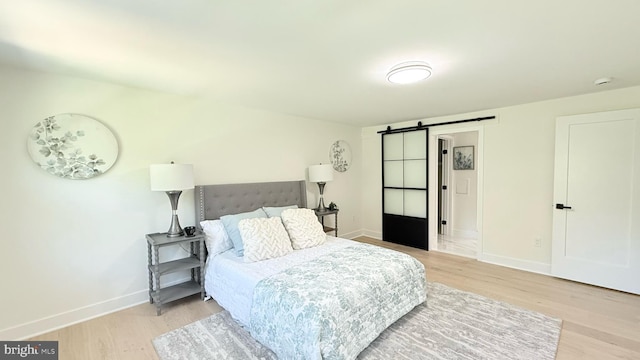 904 Man O War Ln, Great Falls, VA 22066 - bedroom featuring a barn door and light wood finished floors