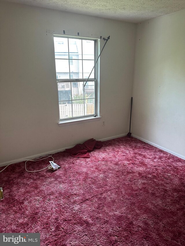 2407 E Rosecroft Village Cir, Oxon Hill, MD 20745 - carpeted spare room with a textured ceiling and baseboards