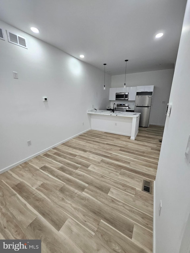 3239 N 13th St, Philadelphia, PA 19140 - kitchen featuring appliances with stainless steel finishes, white cabinetry, a peninsula, recessed lighting, and decorative light fixtures