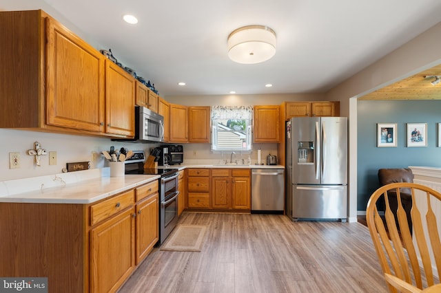 1015 Jodie Ct, Pennsburg, PA 18073 - kitchen featuring appliances with stainless steel finishes, light wood-style floors, light countertops, recessed lighting, and brown cabinetry