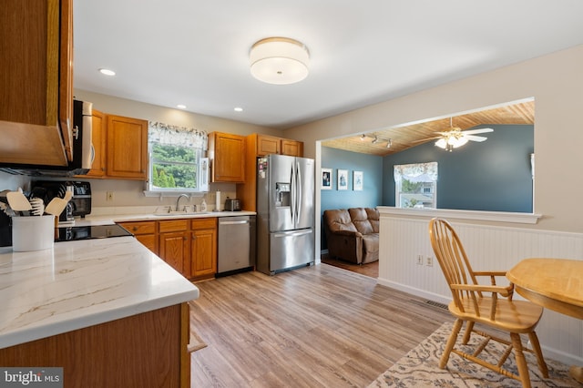 1015 Jodie Ct, Pennsburg, PA 18073 - kitchen with stainless steel appliances, light wood-style floors, lofted ceiling, wainscoting, and brown cabinetry