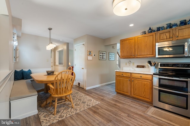 1015 Jodie Ct, Pennsburg, PA 18073 - kitchen featuring stainless steel appliances, light countertops, light wood finished floors, brown cabinets, and recessed lighting