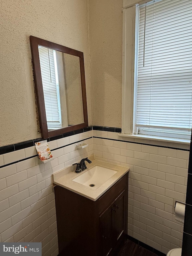 1812 E 32nd St, Baltimore, MD 21218 - bathroom featuring tile walls, vanity, and a wainscoted wall