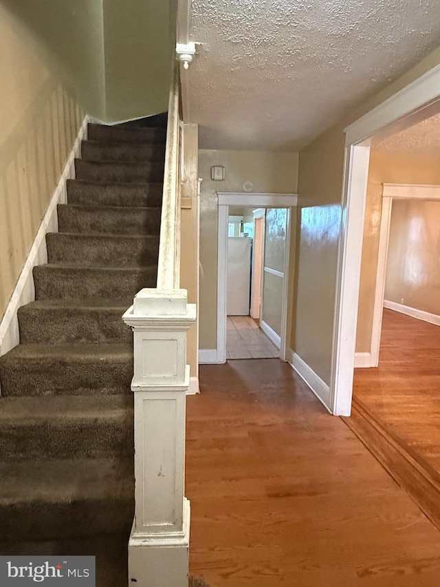 1812 E 32nd St, Baltimore, MD 21218 - stairs with wood finished floors and a textured ceiling