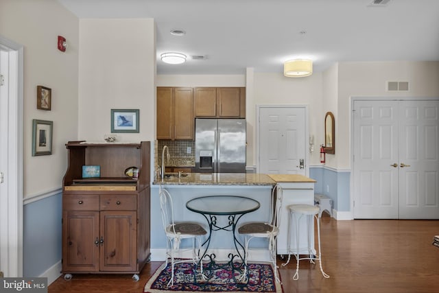 7330 Maple Ave Unit 116, Pennsauken, NJ 08109 - kitchen with stainless steel fridge, brown cabinets, a peninsula, decorative backsplash, and dark wood-style flooring