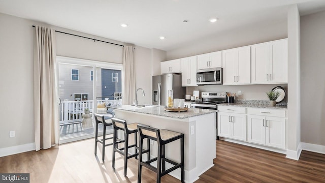 178 Munsee Cir, Winchester, VA 22602 - kitchen with stainless steel appliances, a kitchen island with sink, white cabinetry, dark wood-type flooring, and recessed lighting