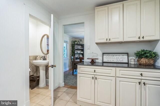 614 Radnor Ave, Haddonfield, NJ 08033 - kitchen featuring light tile patterned flooring, dark countertops, ornamental molding, and white cabinetry