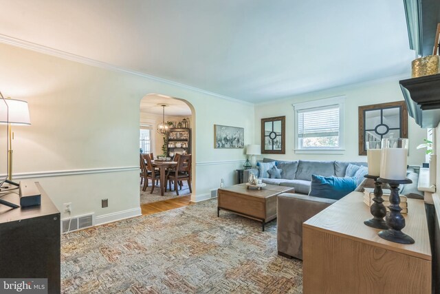 614 Radnor Ave, Haddonfield, NJ 08033 - living room with arched walkways, plenty of natural light, ornamental molding, wood finished floors, and a chandelier