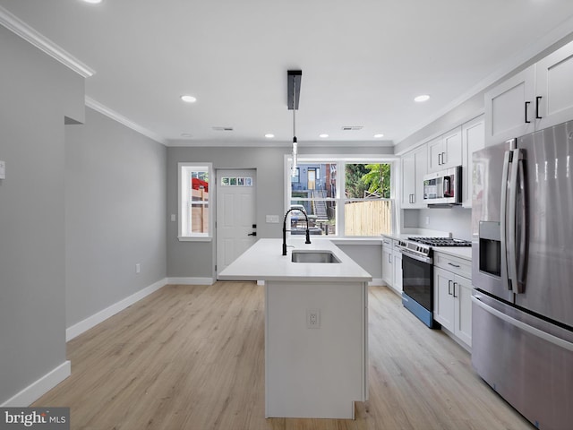 1759 Lyman Pl NE, Washington, DC 20002 - kitchen featuring appliances with stainless steel finishes, ornamental molding, an island with sink, light wood-style flooring, and white cabinetry