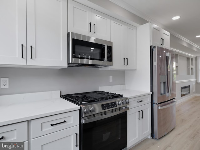 1759 Lyman Pl NE, Washington, DC 20002 - kitchen featuring stainless steel appliances, white cabinetry, light wood-type flooring, crown molding, and recessed lighting