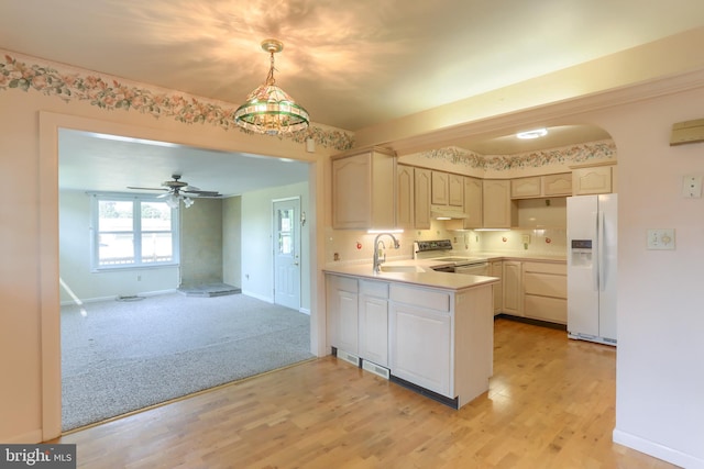 811 S Harrison St, Palmyra, PA 17078 - kitchen with white appliances, a peninsula, under cabinet range hood, light countertops, and arched walkways