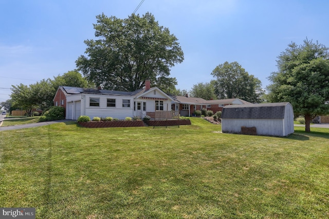 811 S Harrison St, Palmyra, PA 17078 - view of front of property with a storage shed, a front lawn, a garage, and asphalt driveway