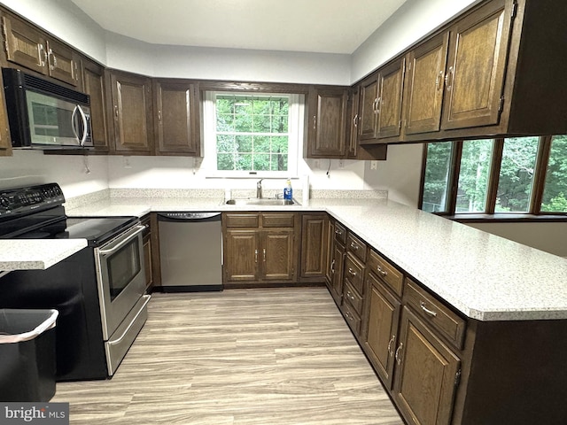16611 Summers Ln, Brandywine, MD 20613 - kitchen with appliances with stainless steel finishes, light countertops, a peninsula, and dark brown cabinetry