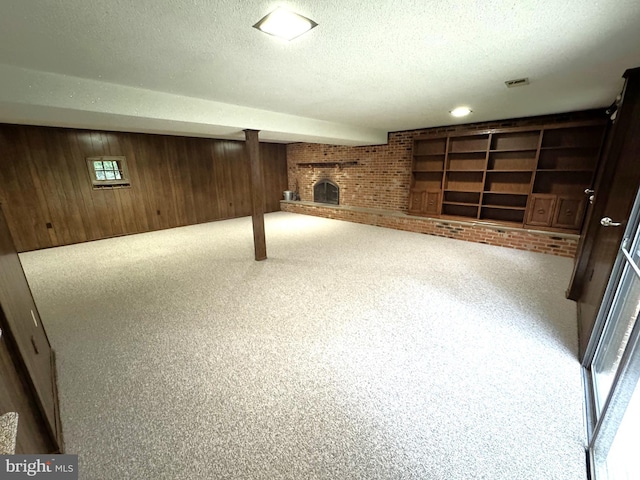 16611 Summers Ln, Brandywine, MD 20613 - below grade area with a fireplace, wooden walls, a textured ceiling, brick wall, and carpet floors