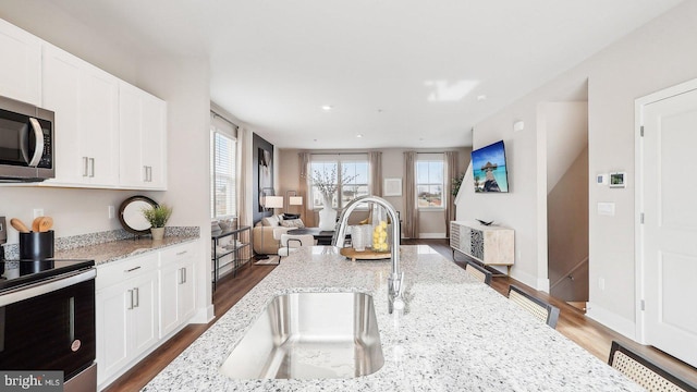 176 Munsee Cir, Winchester, VA 22602 - kitchen with electric stove, stainless steel microwave, plenty of natural light, open floor plan, and recessed lighting